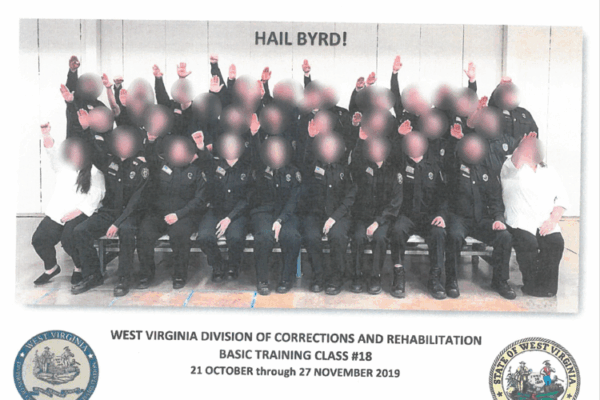 Photo shows a class of WV Corrections cadets, arms raised in a Nazi salute. Faces are blurred.