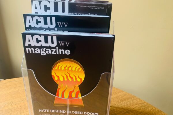 2021 ACLU-WV Magazine cover features image of flames seen through a keyhole with the words: Hate Behind Closed Doors