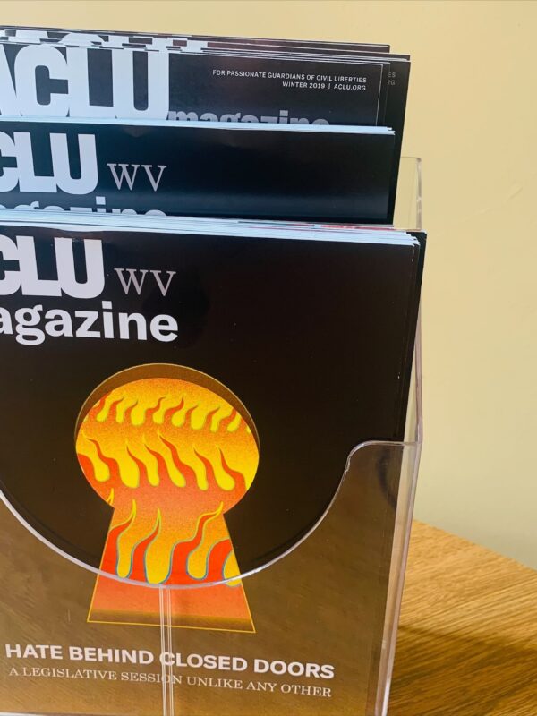 2021 ACLU-WV Magazine cover features image of flames seen through a keyhole with the words: Hate Behind Closed Doors