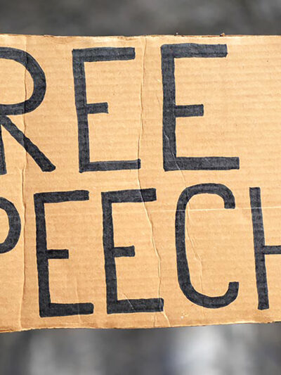 A handmade sign reading "FREE SPEECH"