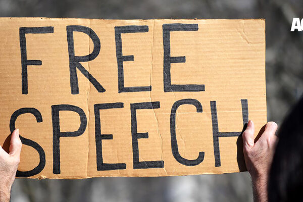 A handmade sign reading "FREE SPEECH"