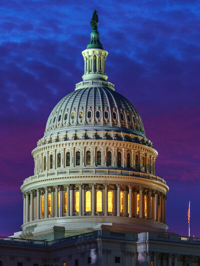 The United States Capitol building is shown at night.