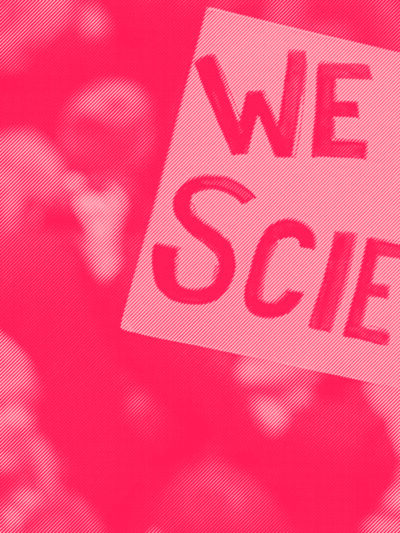 A protester holds a sign saying We Love Science