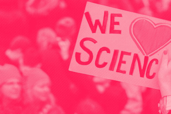 A protester holds a sign saying We Love Science