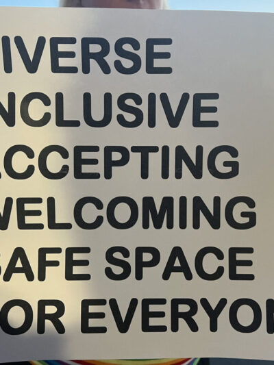 A sign reads "DIVERSE INCLUSIVE WELCOMING SAFE SPACE FOR EVERYONE"