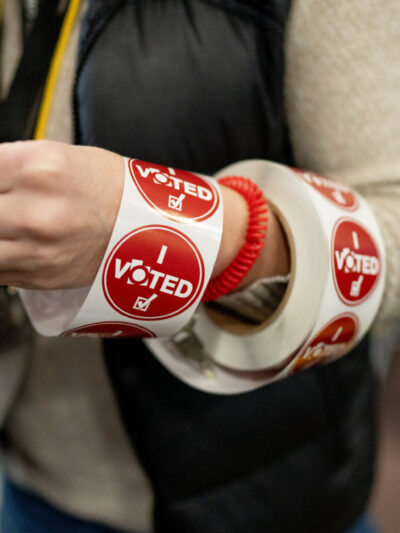 A ream of red "I voted" stickers wrapped around a poll workers arm.