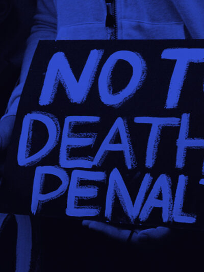 "NO TO THE DEATH PENALTY" in bright blue letters on a black sign.