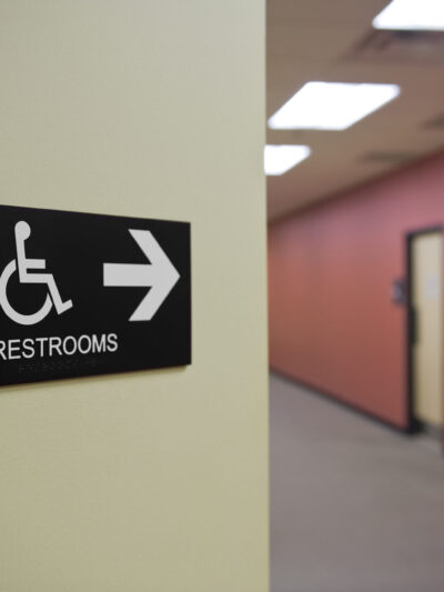 A sign points down a hallway to restrooms.