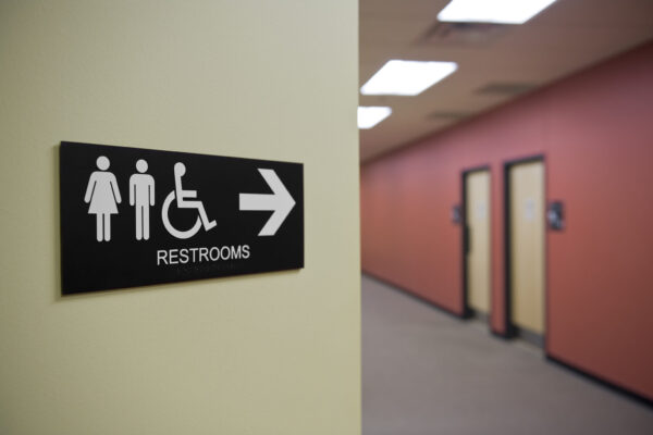 A sign points down a hallway to restrooms.