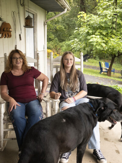 Becky Pepper Jackson and her mother Heather Jackson sit on the porch of their home with their two black labs.