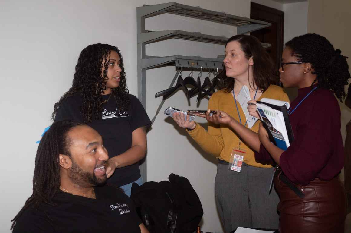 Reporters interview ACLU-WV supporters as they braid hair in front of the office of Senator Eric Tarr, who derailed the Crown Act from passing the Seante last week.