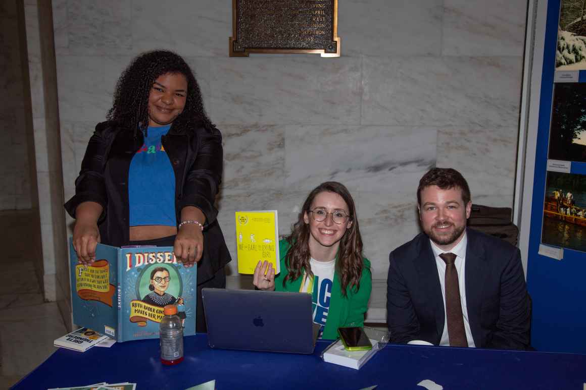 Staff members show off children's books that some state lawmakers have considered banning or restricting from public libraries in recent years. 