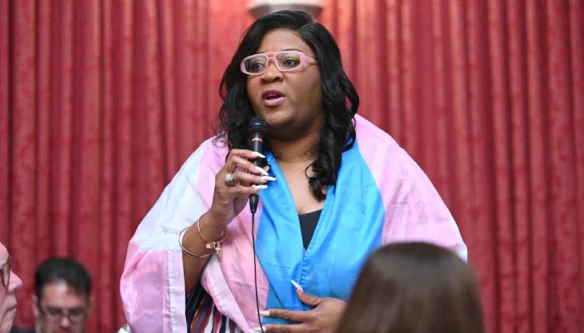 Danielle Walker wears a trans pride flag over her shoulders while addressing the House of Delegates