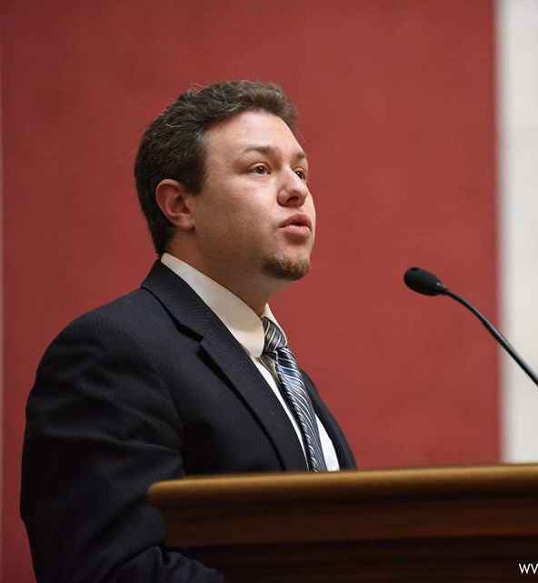 Eli Baumwell speaks into a microphone during a public hearing at the West Virginia Legislature 