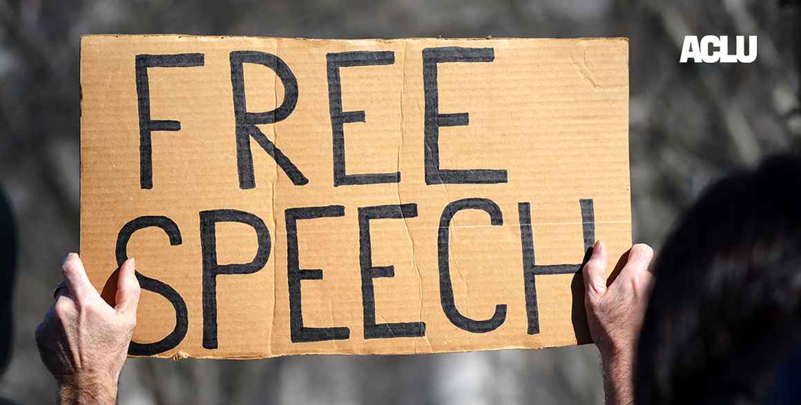 A handmade sign reading "FREE SPEECH"