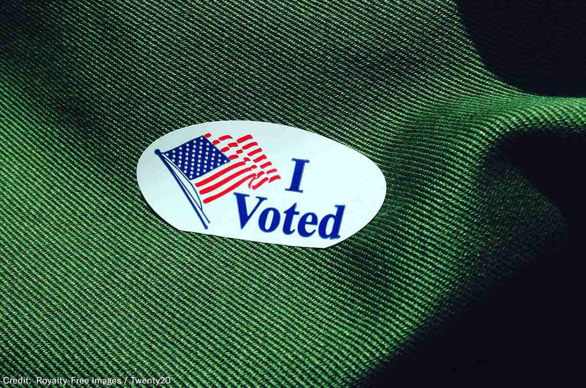 Photo of a sticker that says "I voted" with a waving American flag