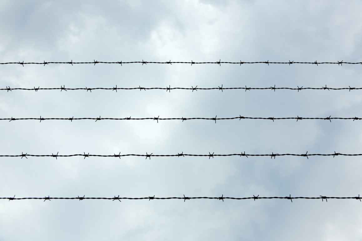 A photo of prison wire against a sky