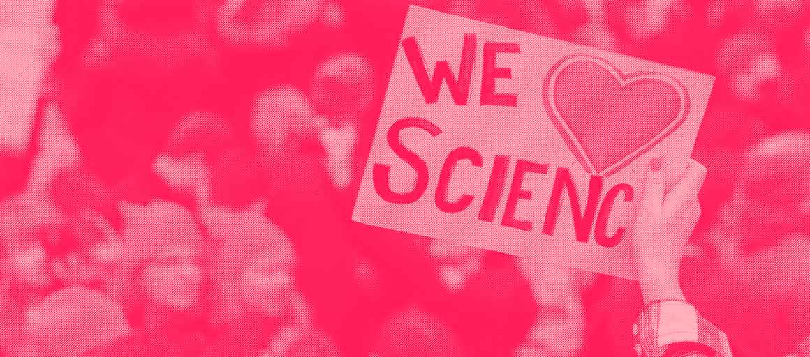 A protester holds a sign saying We Love Science