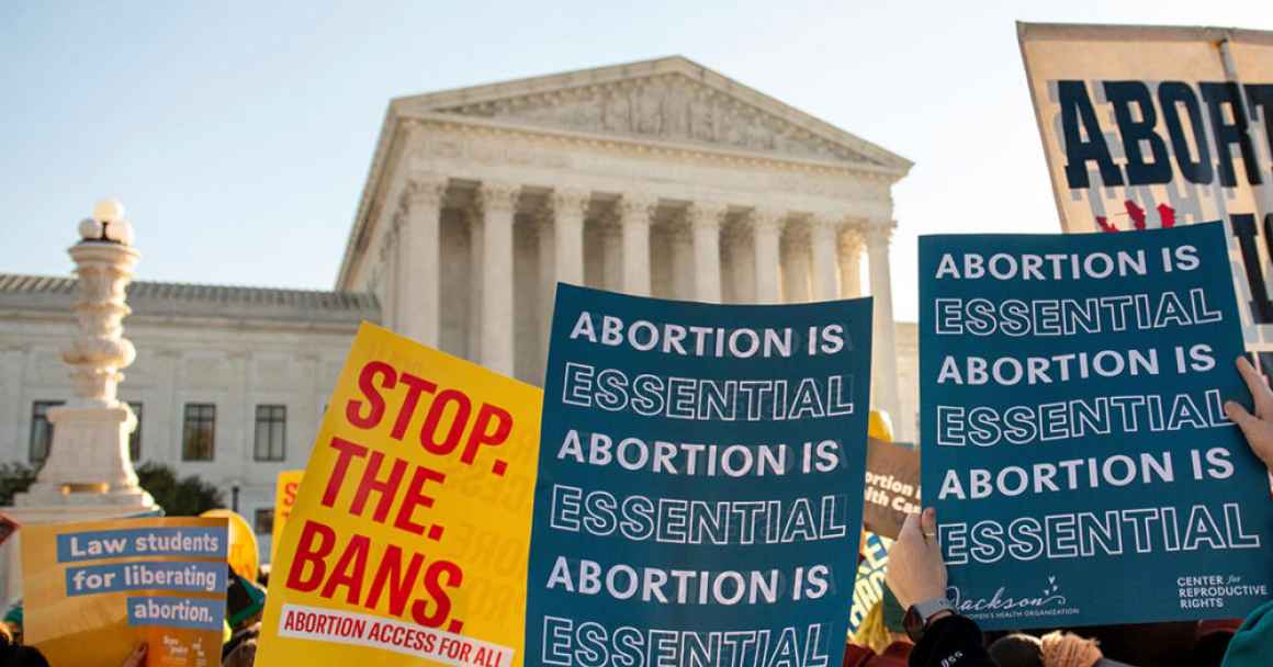 Signs saying Stop. The. Bans. are waved in front of the U.S. Supreme Court building