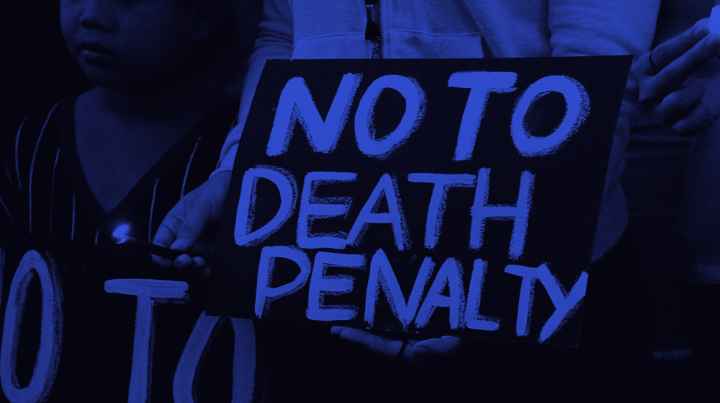 "NO TO THE DEATH PENALTY" in bright blue letters on a black sign.