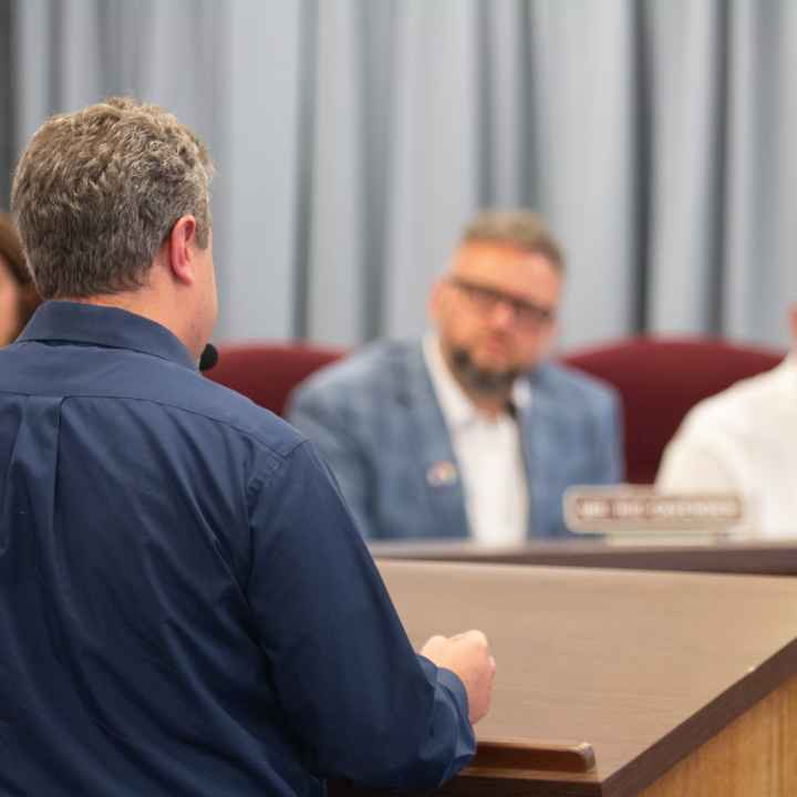 Photo shows Eli Baumwell from behind as he addresses members of the Kanawha County Board of Education