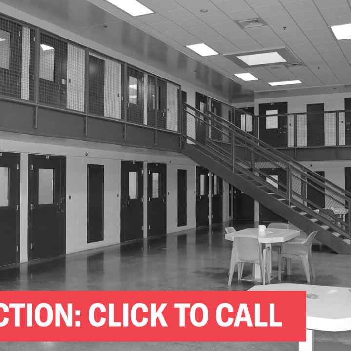 A black and white photo of a cell block with the words "Take Action; Click to Call"