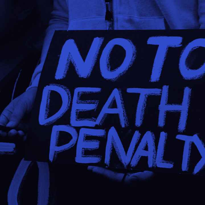 "NO TO THE DEATH PENALTY" in bright blue letters on a black sign.
