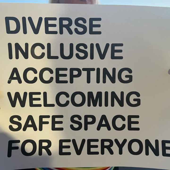 A sign reads "DIVERSE INCLUSIVE WELCOMING SAFE SPACE FOR EVERYONE"