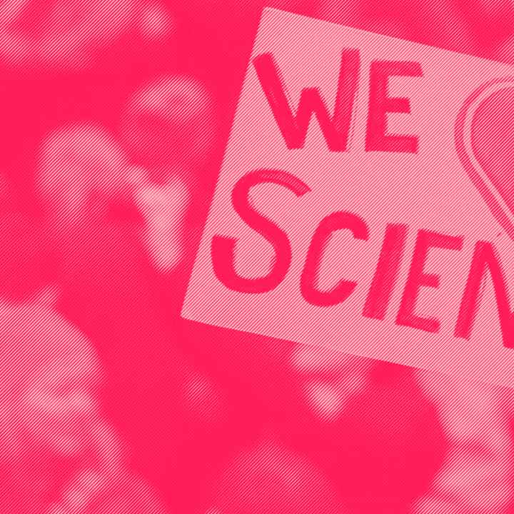 A protester holds a sign saying We Love Science